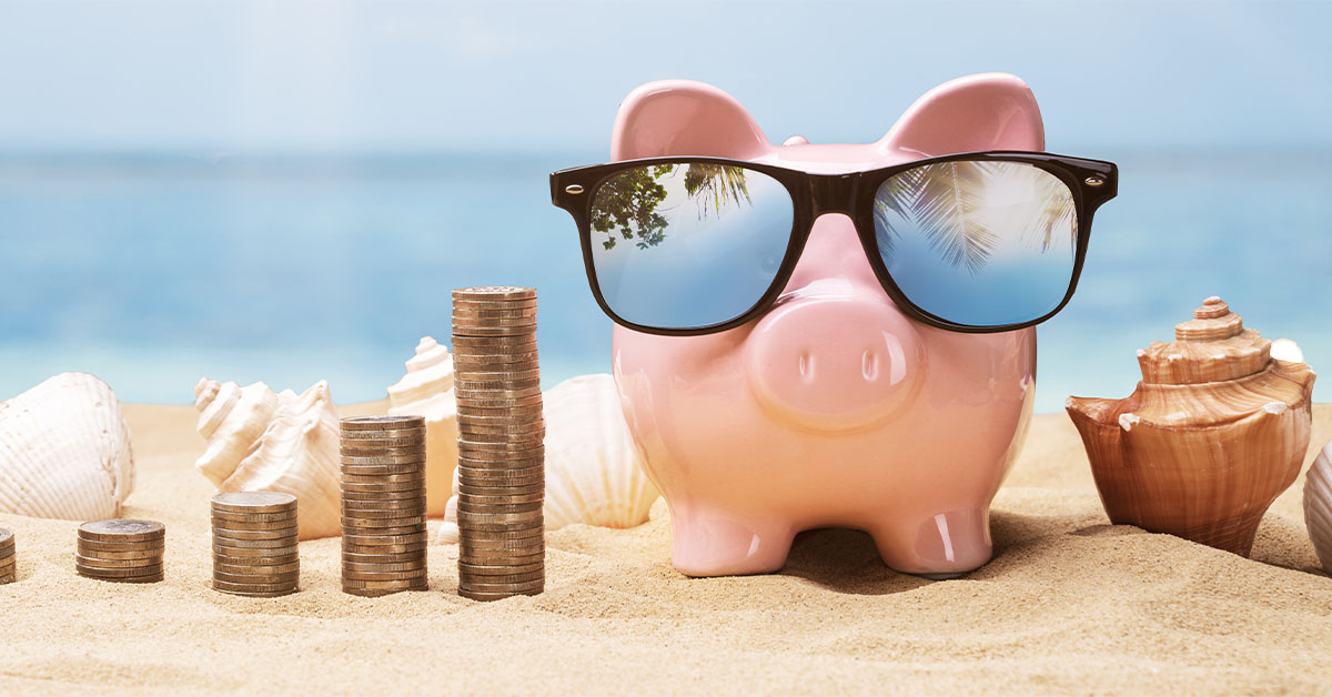 Retired piggy bank on the beach with sunglasses on.