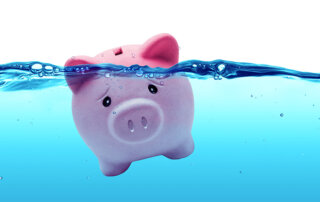 Stressed piggy bank floating in water.